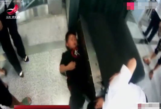 小屁孩趁爷爷不注意悄悄捣乱,将棍子塞入安检机,結果胳膊被卡死了